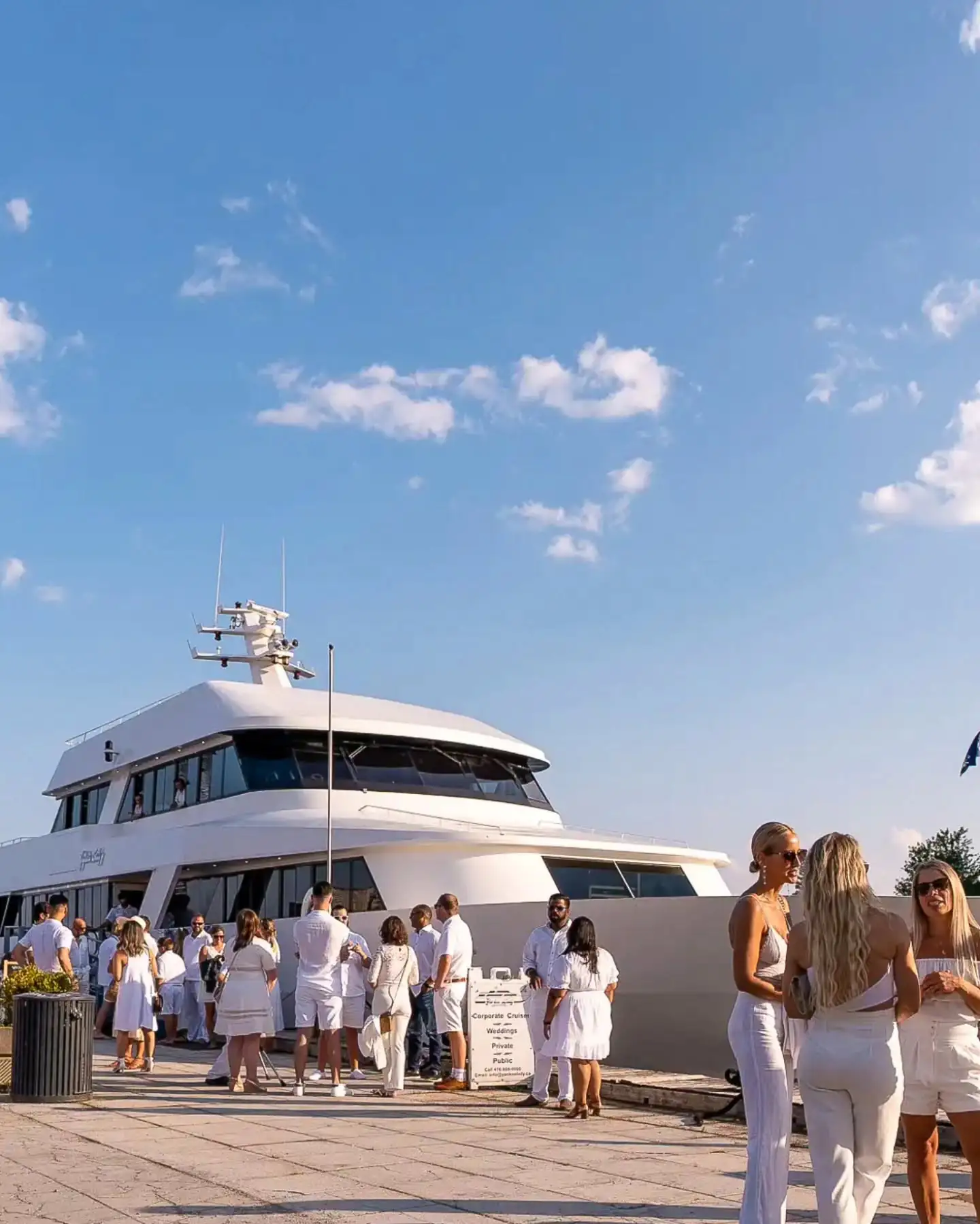 Guests dressed in white gathering beside Yankee Lady at the dock