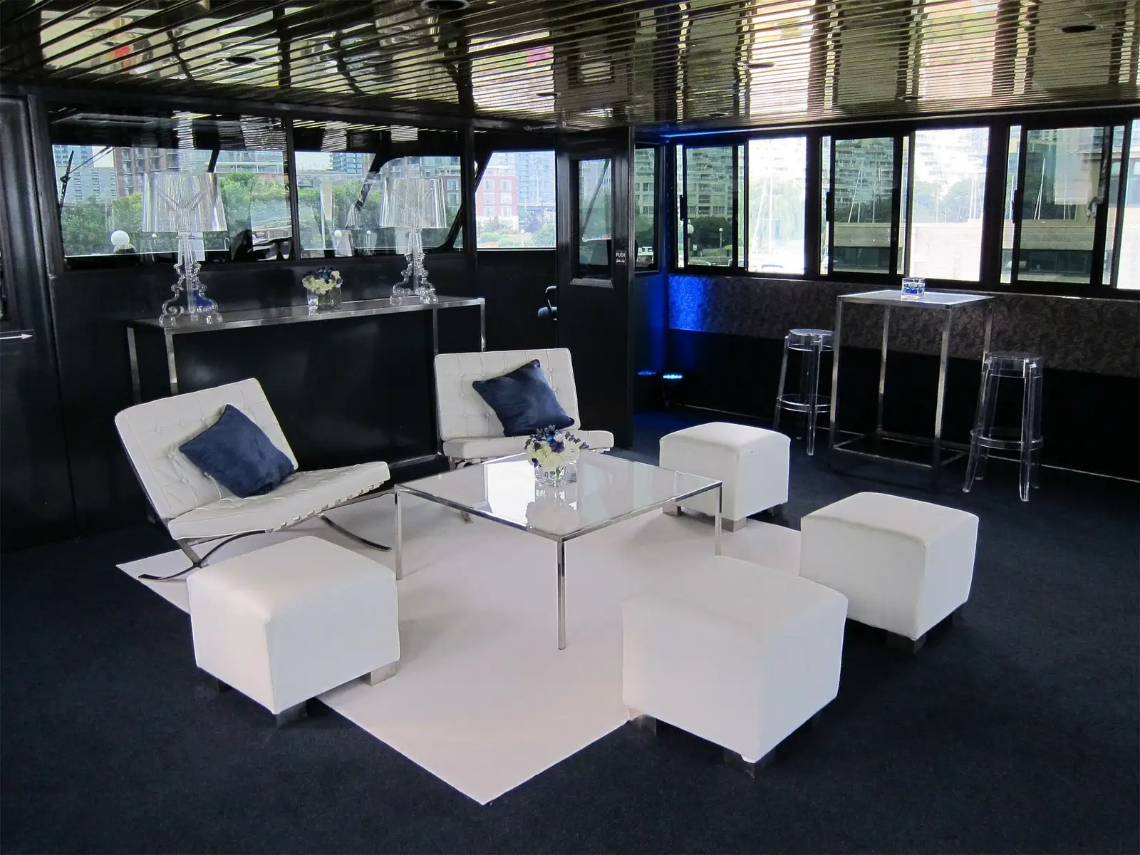 Indoor lounge with white seating and harbour views