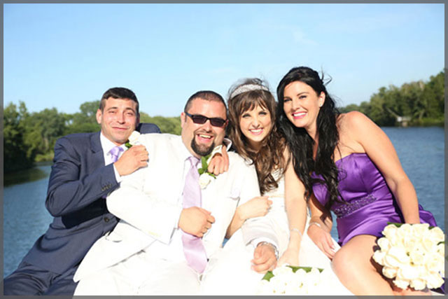 Bride and groom celebrate their wedding with the best man and bridesmaid on their wedding cruise.