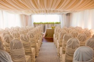 Sultans tent wedding decor with chair covers and drapery.