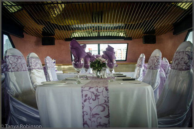 Wedding decor with mauve accents on chairs, table runners and napkins.