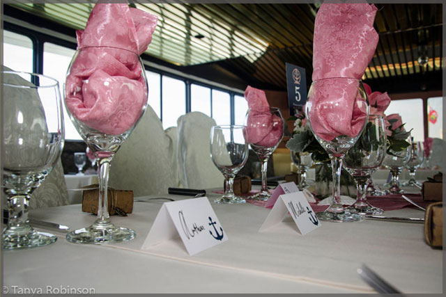 Wine glasses with pink wedding decor.