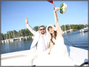 Bride and groom celebrating their wedding on the bow of the boat.