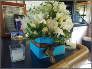 Floral centrepiece with white accent flowers for wedding cruise.