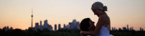 Bride and groom hugging with the Toronto skyline in the background.