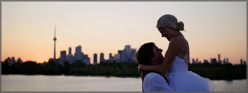 Wedding packages with Bride and groom hugging with the Toronto skyline in the background at sunset.