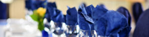 Blue napkins in wine glasses.