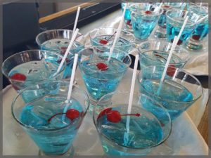 Blue martinis with maraschino cherry.