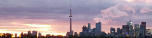 Toronto skyline at sunset with CN Tower in the middle.