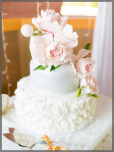 Three tier wedding cake with icing pink roses.