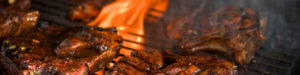 Steaks grilling over a bed of coals.