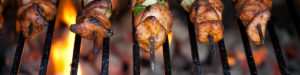 Skewers of chicken grilling over a bed of coals.