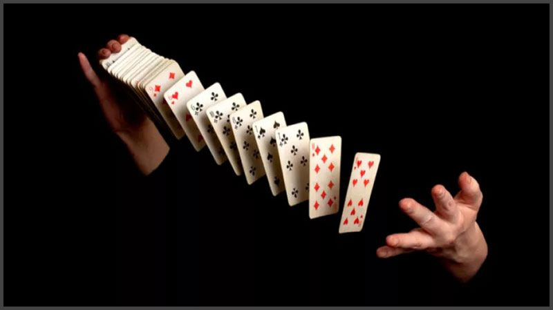 Magician shuffling a deck of cards with his body blacked out.