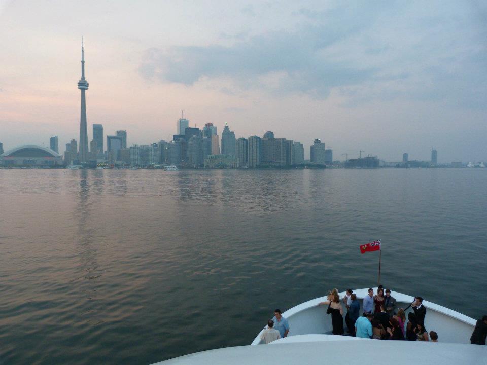 Yankee Lady Yacht cruising Lake Ontario. The scenery is Toronto city's skyline, the sun is setting and the weather looks a bit foggy